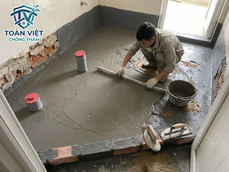 Cách chống thấm nhà vệ sinh cũ không đục gạch, đục nền 2026 10 Cán lớp vữa xi măng bảo vệ bề mặt màng chống thấm khỏi bị trầy xước trong quá trình ốp lát gạch mới