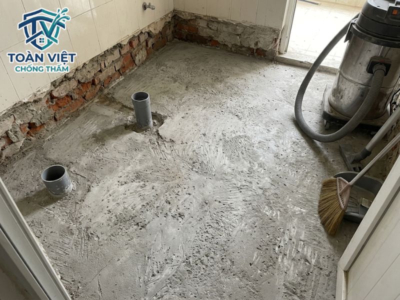 Cách chống thấm nhà vệ sinh cũ không đục gạch, đục nền 2026 5 Đục bỏ toàn bộ gạch cũ và lớp vữa lót, mài sạch tới tận mặt sàn bê tông kết cấu trước khi chống thấm
