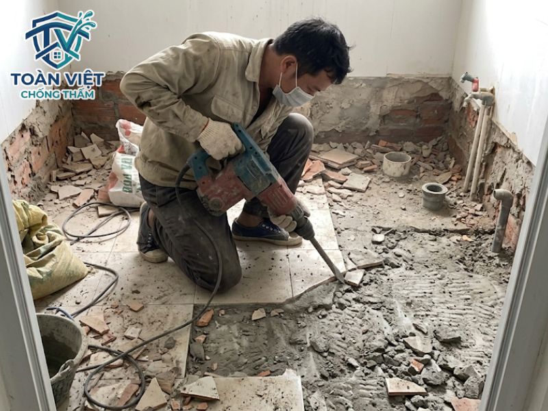 Đục bỏ toàn bộ lớp gạch cũ và mài sạch sàn bê tông gốc để hóa chất chống thấm bám dính tốt nhất