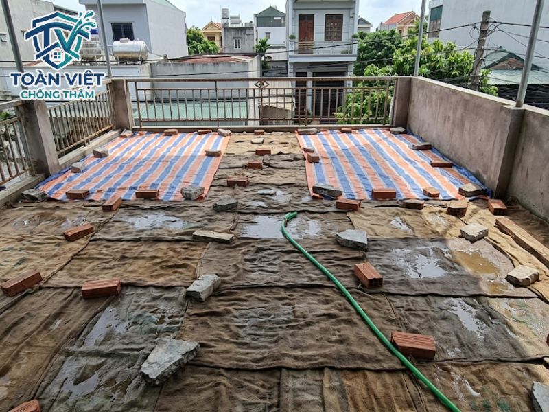 Phủ bạt hoặc bao tải ẩm để bảo dưỡng, giúp xi măng khô từ từ và không bị nứt
