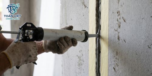 Dùng súng chuyên dụng bơm keo Sikaflex điền đầy đặc chắc vào khe lún