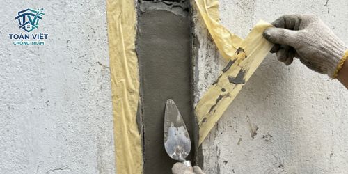 Miết phẳng bề mặt keo Sikaflex và bóc băng keo giấy để hoàn thiện thẩm mỹ cho khe nứt
