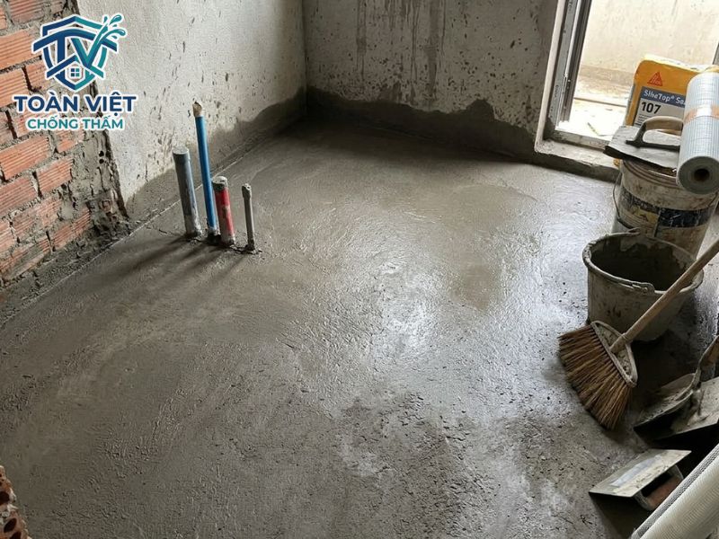 Bề mặt sàn bê tông được mài sạch vữa yếu và phun nước tạo độ ẩm bão hòa trước khi quét Sika